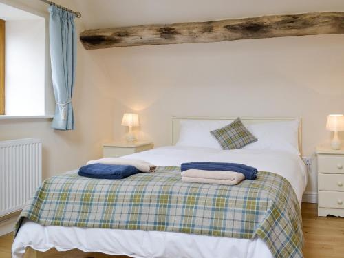 a bedroom with a bed with two towels on it at No, 2 Ash Cottage in Quatt
