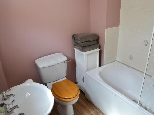 a bathroom with a toilet and a tub and a sink at The Waiting Rooms in Cawston