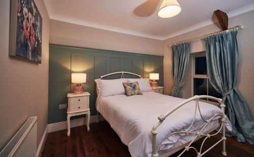 - une chambre avec un lit, deux lampes et une fenêtre dans l'établissement Castell Y Waun- Beautiful and spacious country farmhouse with luxury Hot Tub & Grounds, à Carmarthen