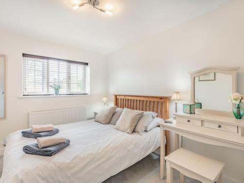 a bedroom with a bed with a mirror and a desk at Tea Pot Cottage in Ringwood