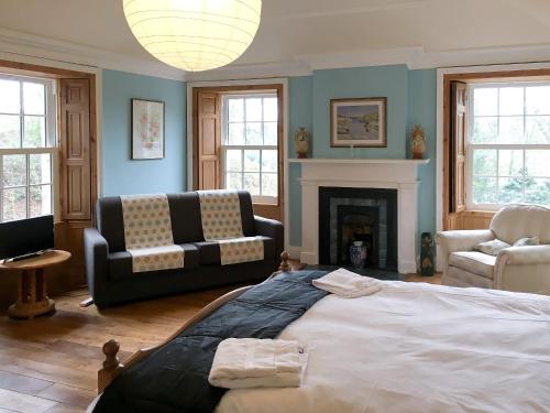 a bedroom with a bed and a couch and a fireplace at The Moat House in Annan