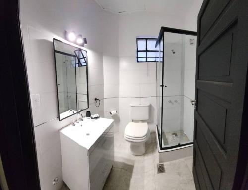y baño blanco con aseo y ducha. en Aventura 550 en Buenos Aires