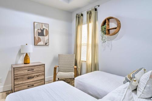 ein weißes Schlafzimmer mit 2 Betten und einem Stuhl in der Unterkunft Indianapolis Vacation Home 3 Mi to Dtwn! in Indianapolis
