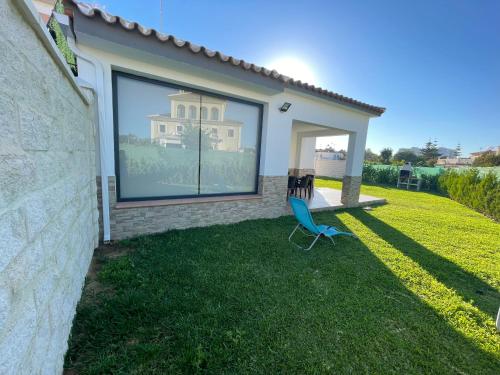 a yard with two chairs in front of a house at La Juli, Exclusivo chalet nuevo, de lujo in Matalascañas