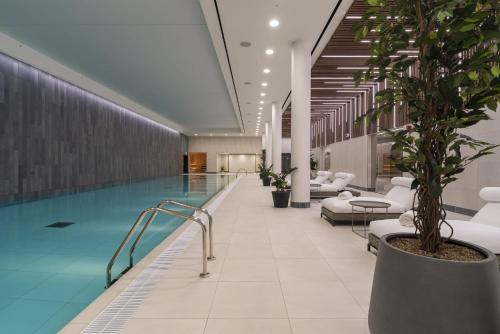 einen Pool in einer Hotellobby mit Topfpflanze in der Unterkunft One and Two Bedroom Apartments at Coppermaker Square in Lively Stratford in London