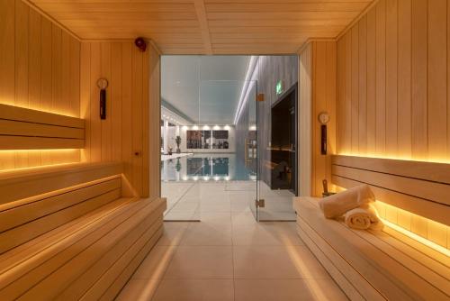 uma sauna com paredes com painéis de madeira e um corredor em One and Two Bedroom Apartments at Coppermaker Square in Lively Stratford em Londres