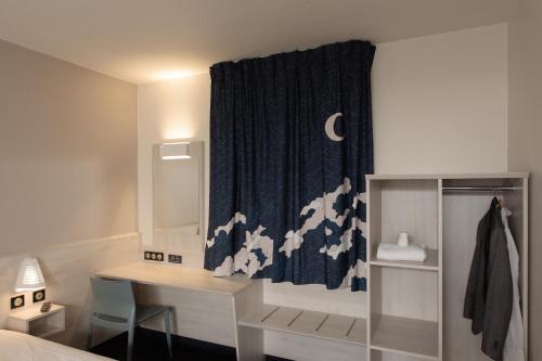 een slaapkamer met een bureau en een gordijn met de maan bij ACE Hôtel Lyon Vénissieux Parc des Expositions in Vénissieux