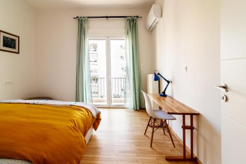 Schlafzimmer mit einem Bett, einem Schreibtisch und einem Fenster in der Unterkunft Luxury Home near Edem Beach in Athen