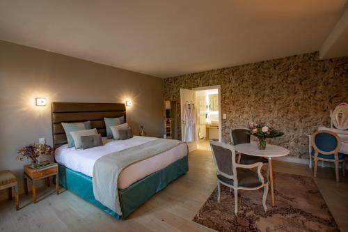 Habitación de hotel con cama, mesa y sillas en Maison Toscane in a remarkable village - heated pool, jacuzzi, billiard & ensuite luxury bedrooms en Terraube
