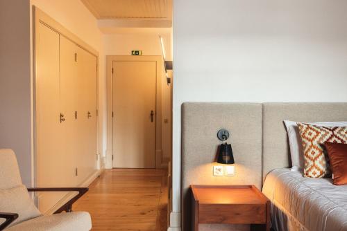 a bedroom with a bed and a hallway with a table at Casa da Ribeira in Marco de Canavezes