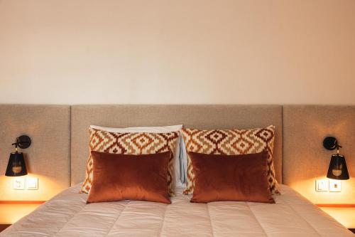 a bed with two pillows on it with two lamps at Casa da Ribeira in Marco de Canavezes