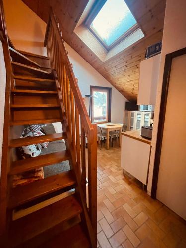 - un escalier en bois dans une cuisine avec une lucarne dans l'établissement Duplex chaleureux, au Monêtier-les-Bains