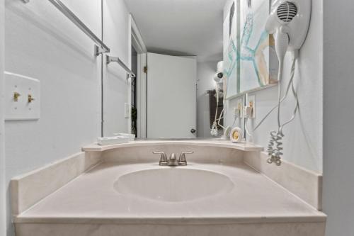 een witte badkamer met een wastafel en een spiegel bij oceanside inn in Daytona Beach