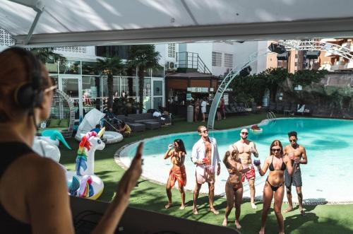 a group of people standing in front of a swimming pool at BC Music Resort in Benidorm