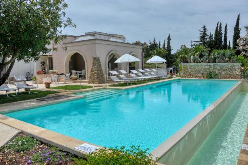 una piscina con sedie e una casa di Cuti Mari a Otranto