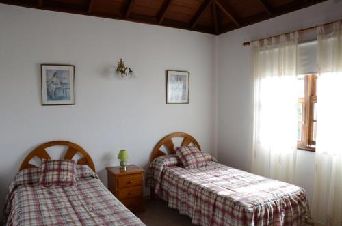 a bedroom with two beds and a window at Las Casitas - Bung. A in Tijarafe