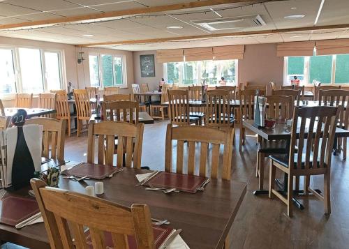 a dining room with wooden tables and chairs at Woodthorpe Leisure Park in Strubby