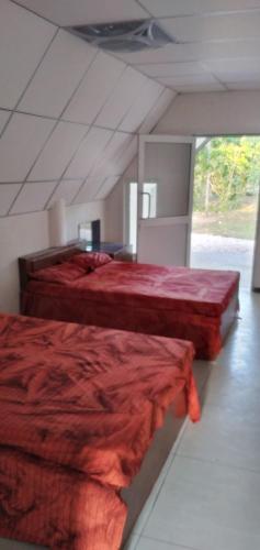 a bedroom with two beds with red comforter at ULPATHA NATURE RESORT in Kurunegala