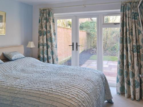 SaxilbyにあるThe Old Forgeのベッドルーム1室(ベッド1台付)、スライド式ガラスドアが備わります。