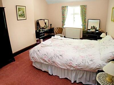a bedroom with a bed and a desk and a window at The Coach House in Wetheral