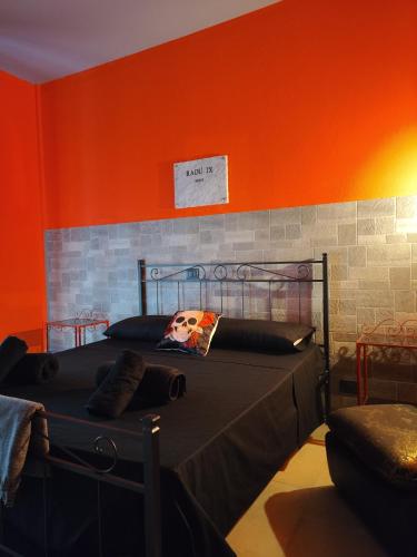 a bedroom with a bed with an orange wall at Hotel Transilvania in Pian del Voglio