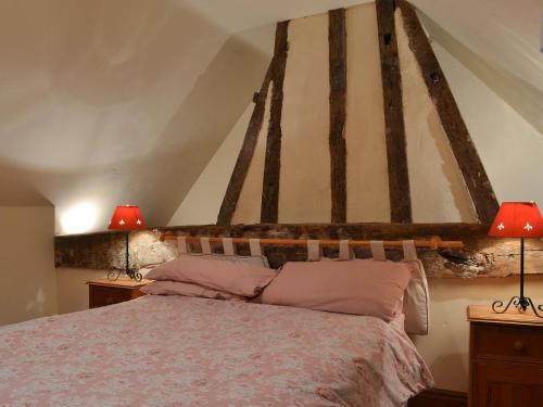 a bedroom with a large bed with two lamps at Tudor House in Easingwold