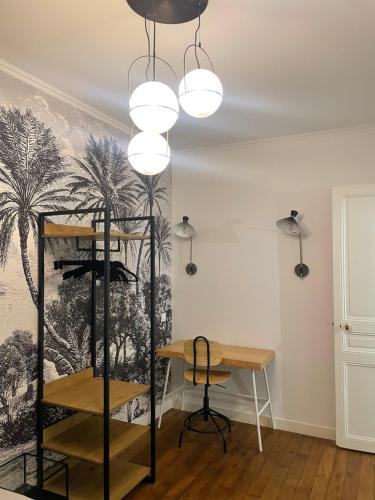 Cette chambre comprend un bureau et un mur orné d'une fresque murale représentant des palmiers. dans l'établissement RESIDENCE NATION, à Paris