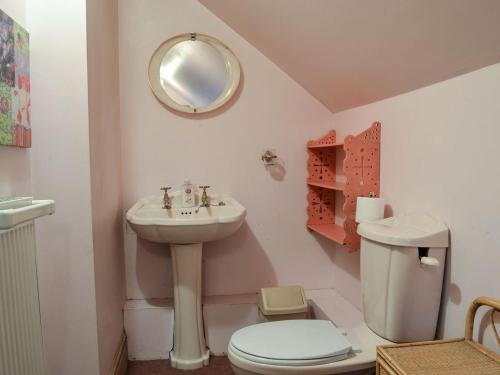 a bathroom with a sink and a toilet and a mirror at Tudor House in Easingwold