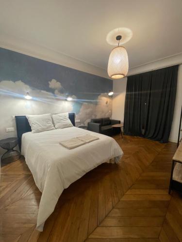 - une chambre avec un grand lit blanc et un mur bleu dans l'établissement RESIDENCE NATION, à Paris