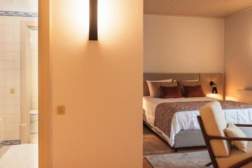 a bedroom with a bed and a light on the wall at Casa da Ribeira in Marco de Canavezes
