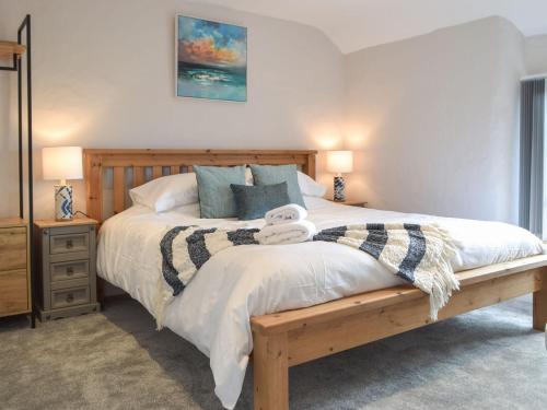 um quarto com uma cama grande e uma estrutura em madeira em Y Bwthyn em Haverfordwest