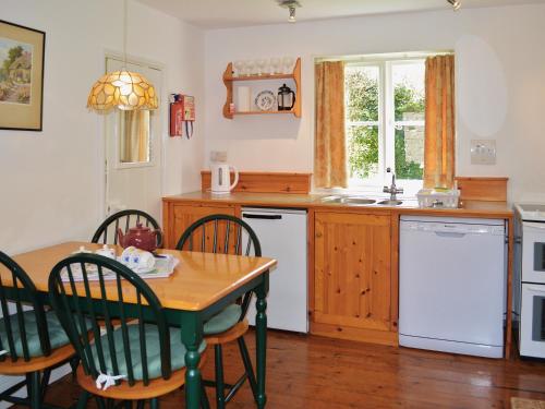 StiffkeyにあるForge Cottageのキッチン(テーブル、椅子、シンク付)