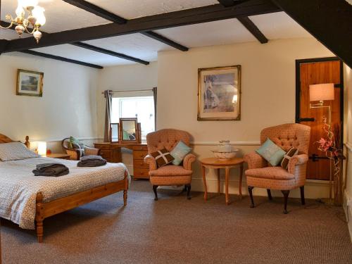 1 dormitorio con 1 cama, 2 sillas y mesa en Brambley Meadow- Uk11725 en Kentisbury