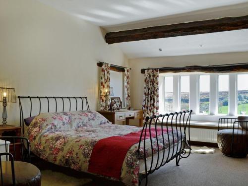 a bedroom with a bed and a large window at Far View Cottage in Haworth