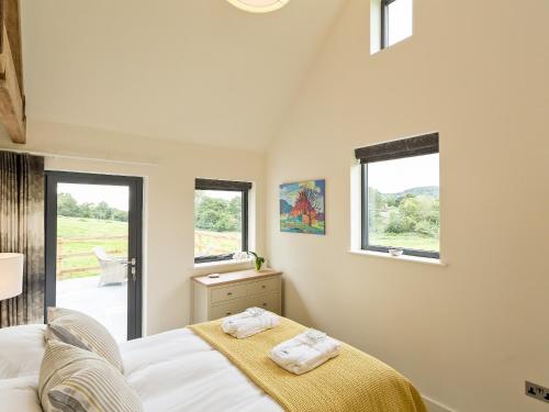a bedroom with a bed and two windows at The Old Piggery in Sidbury
