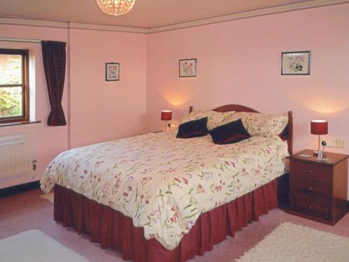 een slaapkamer met een bed met 2 kussens erop bij Stildon Manor Cottage in Pensax