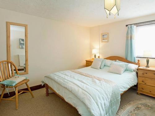 ブランカスターにあるPitts Cottageのベッドルーム1室(ベッド1台、鏡、椅子付)