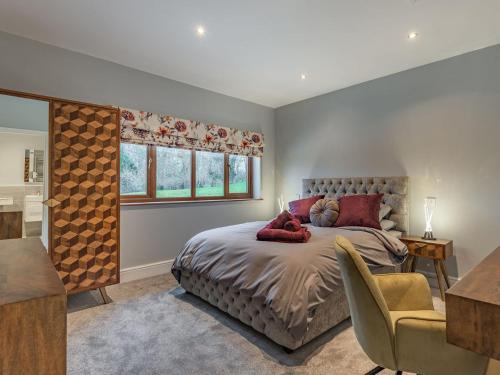 a bedroom with a bed and a chair and a window at Hoole Summer House in Elswick