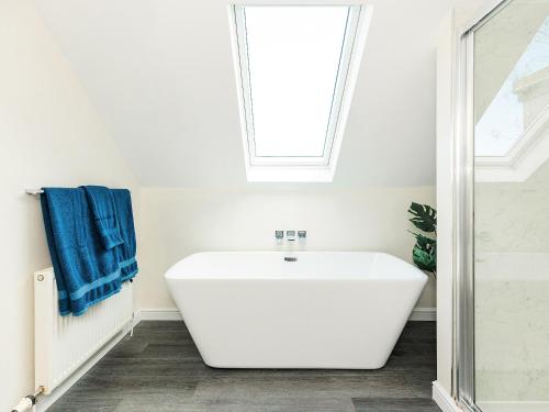 a white bath tub in a bathroom with a window at Robins Nest in Kirkcudbright