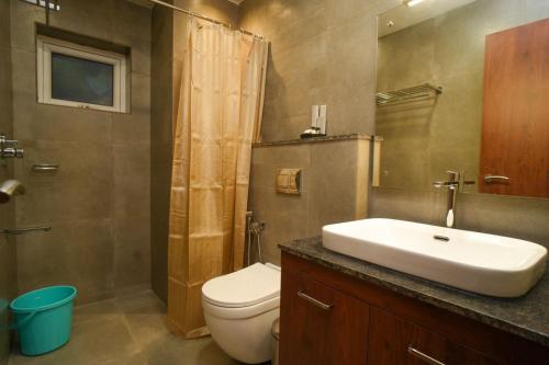 a bathroom with a sink and a toilet and a shower at Royalton Residency in Mundakāyam