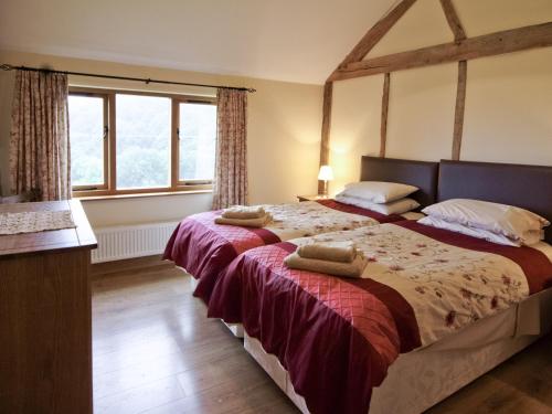 a bedroom with a bed with two pillows on it at Cwm Corn Barn - Hw7662 in Mochdre