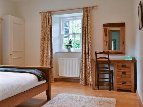 1 dormitorio con cama, escritorio y ventana en Westerton Lodge - Srrh, en Crieff