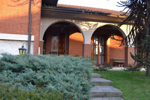 ein Backsteingebäude mit Bögen und Pflanzen davor in der Unterkunft La Filanda B&B in Casorezzo