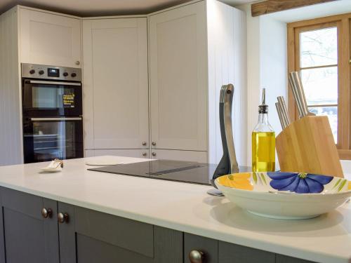 a kitchen with a bowl on a counter with a knife at Lower Goytre Farmhouse in Llanvair Waterdine