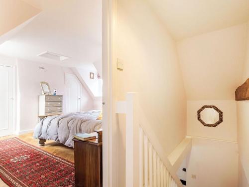 a bedroom with a bed and a mirror on the wall at Riverside Cottage in Bungay