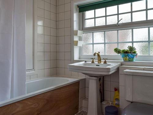 a bathroom with a sink and a bath tub at The Old Post Office in Aston Cantlow