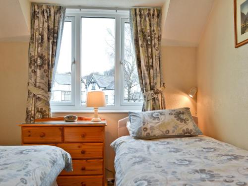 a bedroom with a bed and a window and a dresser at Rainbows End in Bowness-on-Windermere
