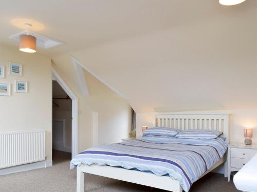 シェリンガムにあるFiley Houseの白いベッドルーム(青い枕のベッド付)