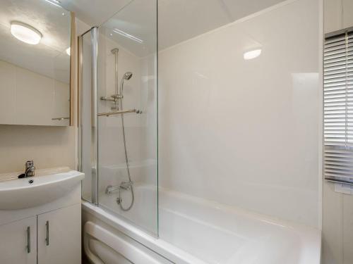a white bathroom with a shower and a sink at The Paddocks - Uk7112 in Dollar