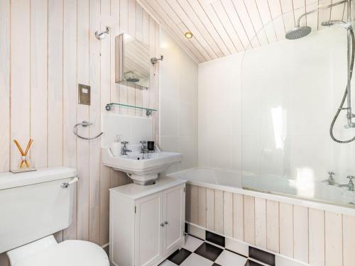 a bathroom with a sink and a tub and a toilet at Laurel Lodge in Willington